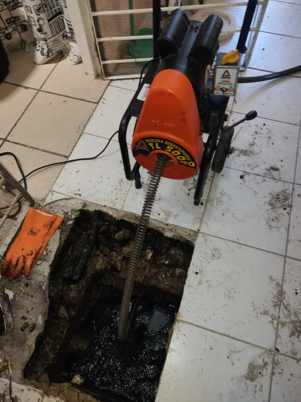 Desentupimento de esgoto com equipamento de mola em ação
