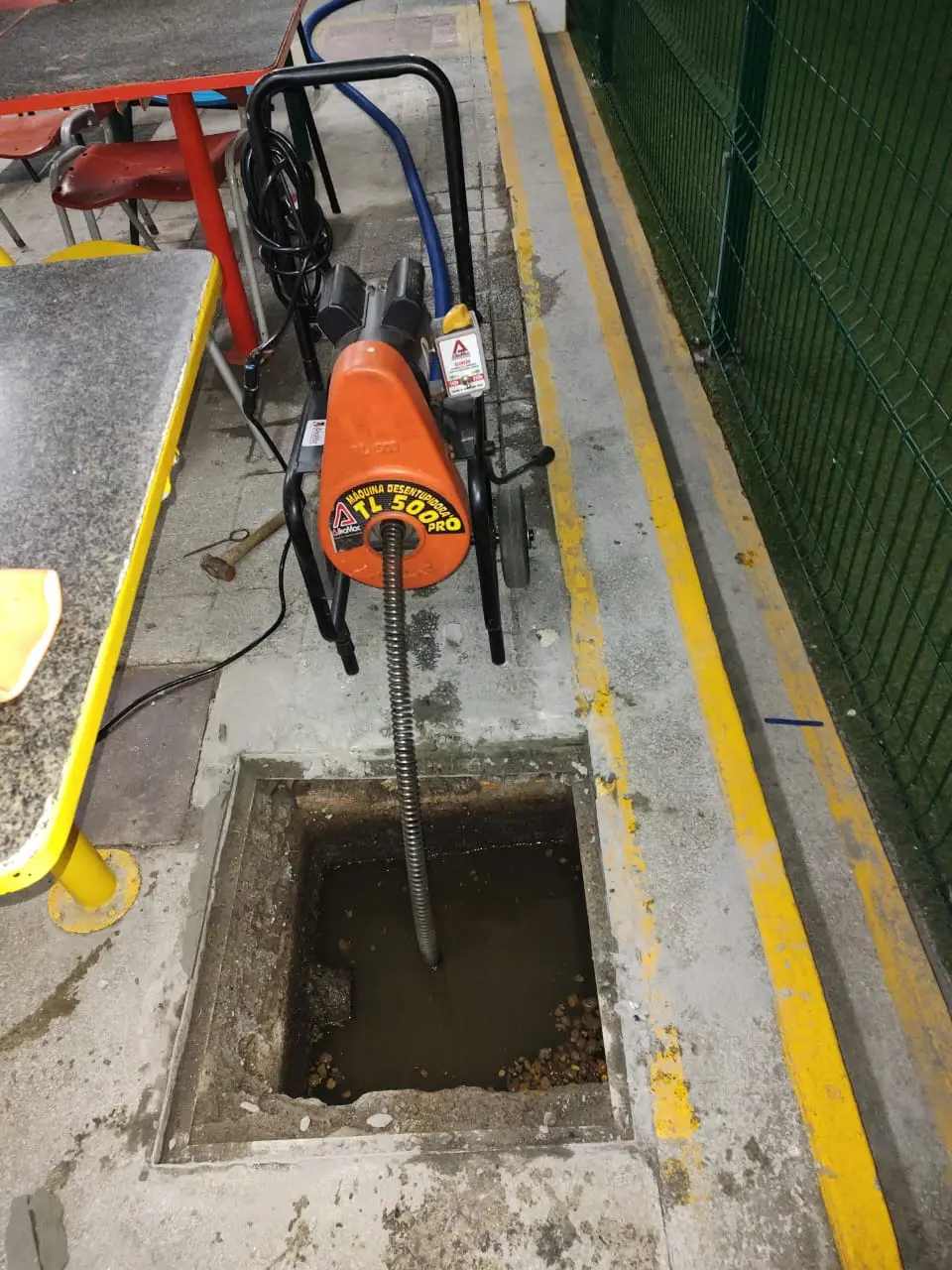 Técnico da JB Desentupidora realizando serviço de desentupimento